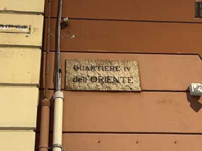 ..., si staglia un�antica targa in pietra che cita testualmente: �Quartiere IV dell�Oriente�